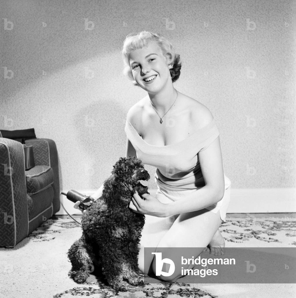Pat Bolton seen here with her pet poodle dog, 1964 (b/w photo)