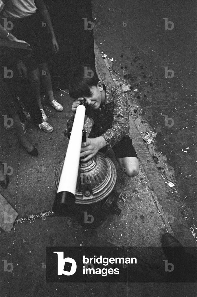 The Beatles in New York City, on their North American Tour a head of their concert to be held at Forest Hills. (picture shows) A young fan looking though a telescope eagerly waiting the arrival of the Beatles. 28th August 1964 (b/w photo)