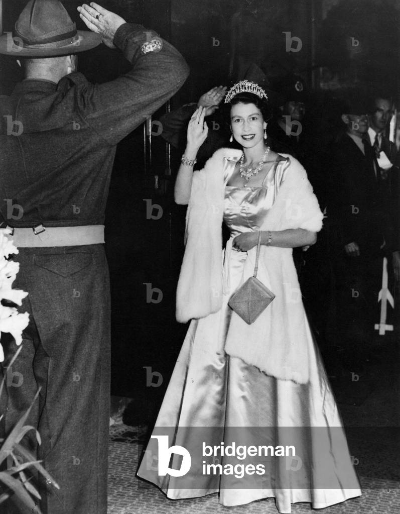 Queen Elizabeth II gives a special wave as enters the Auckland Town Hall, New Zealand, to hold an investiture during the Royal Tour of the Commonwealth, 29th December 1953 (b/w photo)