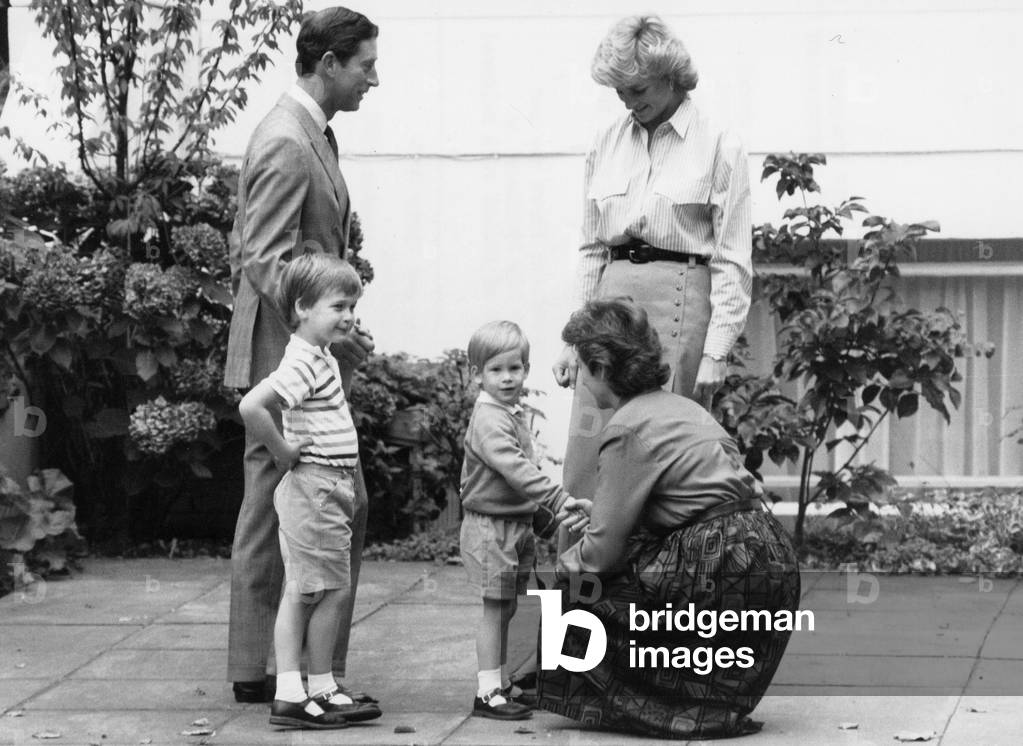Prince Charles and Princess Diana of Wales with their two children Prince William and Prince Harry, meet Mrs Jayne Mynors, the headmistress of Chepstow Villas nursery school in Kensington as Harry starts his first day, 16th September 1987 (b/w photo)