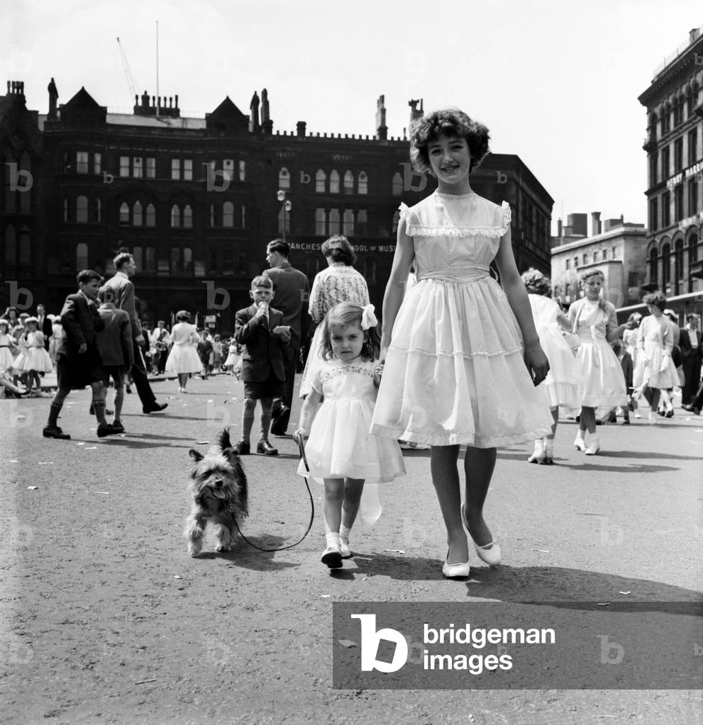 Whit Walks Manchester: The little girl who brought her dog along to walk in the Whit Walks was Diane Pugh aged 3 of Manchester. With her is Anne Grimley aged 11 and, of course, Judy the Yoarkshire terrier. June 1960