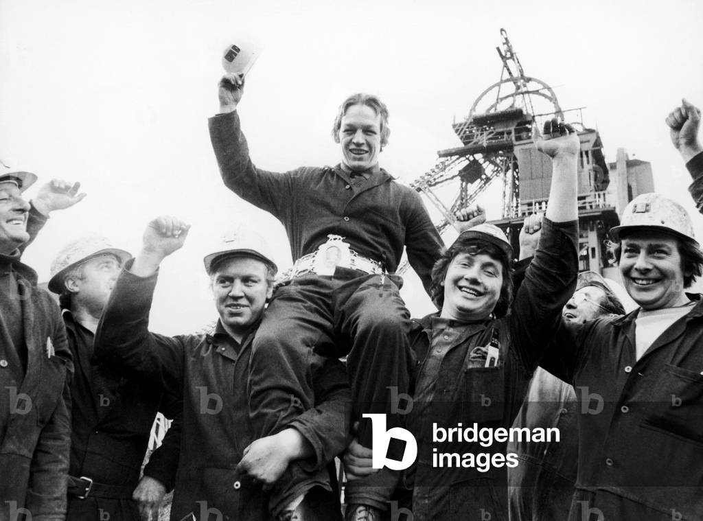 Boxer Alan Richardson is chaired by co-workers at their mine.
21st March 1977.