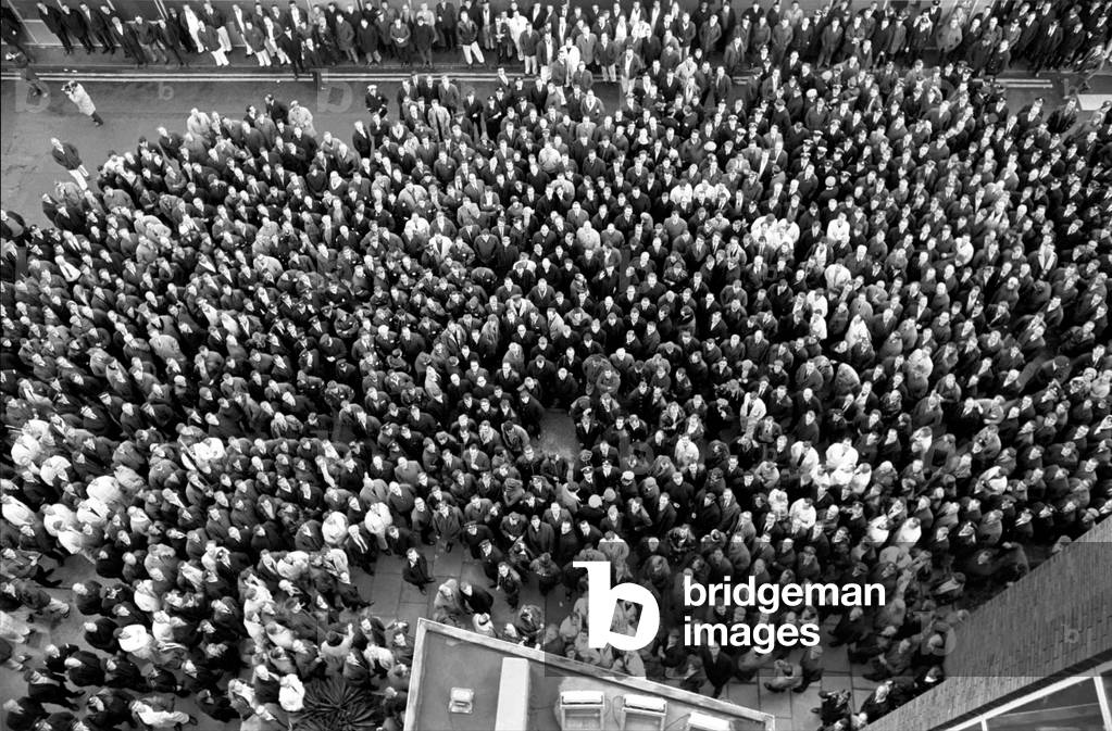 A thousand of Heathrow Airport's 30,000 ground staff stopped work for a mass demonstration today. 
 A view of the protest mass, taken from the 4th floor window of the tower, with them all looking up. 
November 1969