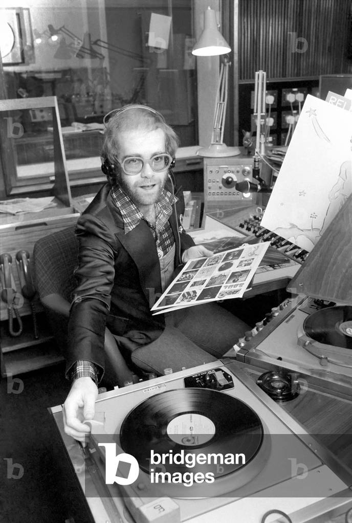 Elton John records his first programme as a disk jockey at the BBC, 2nd March 1975 (b/w photo)