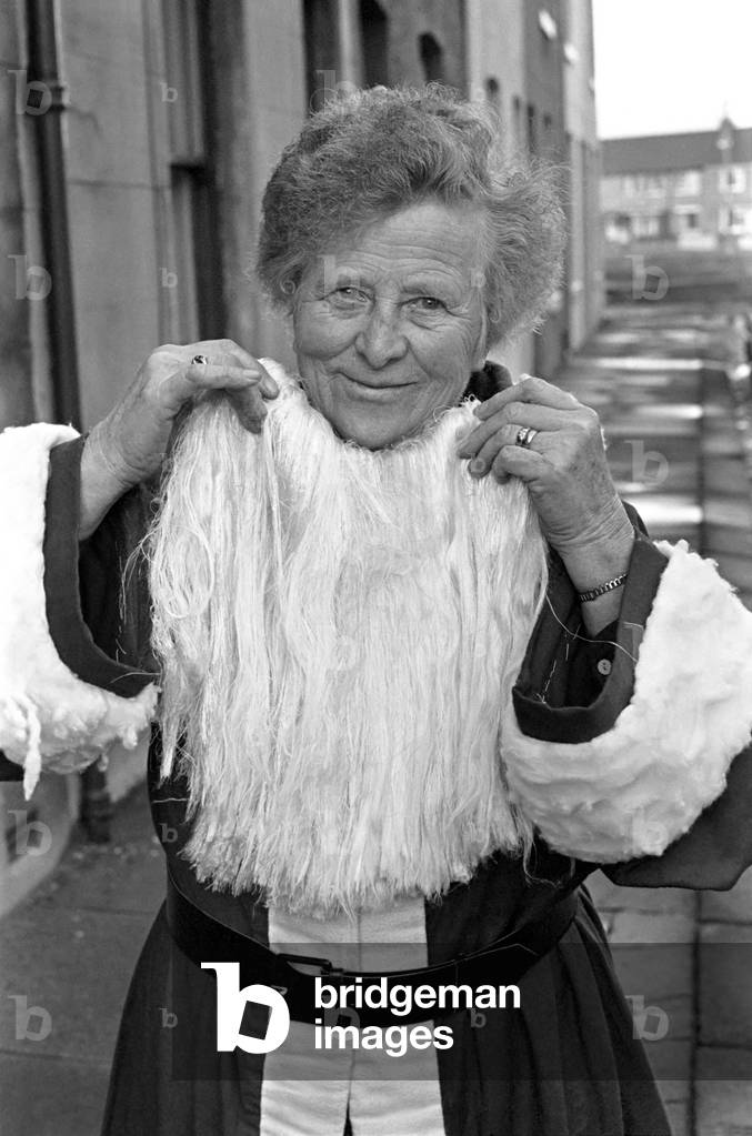 An elderly woman dressed as Santa Claus on her way to engagement accompanied by neighbourhood children. Mrs. Barrett pictured as she is, December 1969
