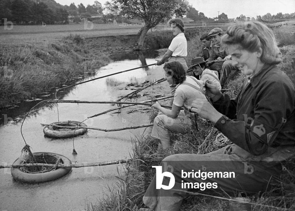 Land Army girls learning the ancient art of eel clotting near Axbridge, Somerset. 11th August 1943 (b/w photo)
