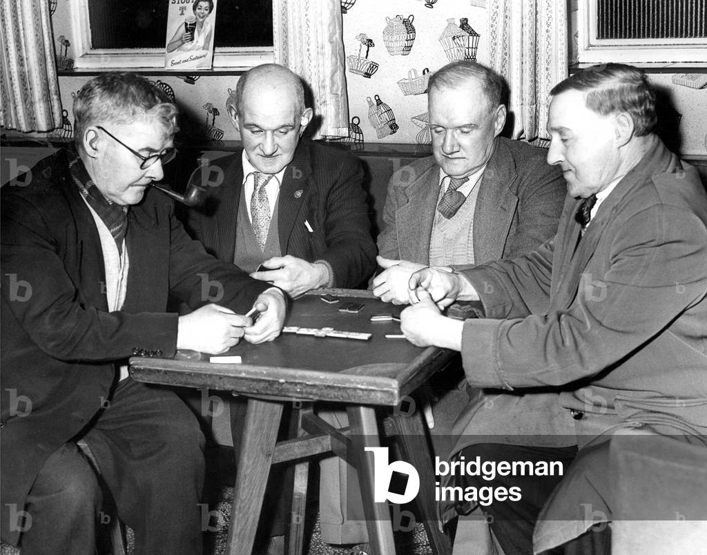 Doorkeeper Dick Marshall (left), forsakes his post at the club's entrance to enjoy a game of dominoes with three other veteran members, Jimmy Redpath, Thomas Rdpath and Thomas Stephenson, 1960