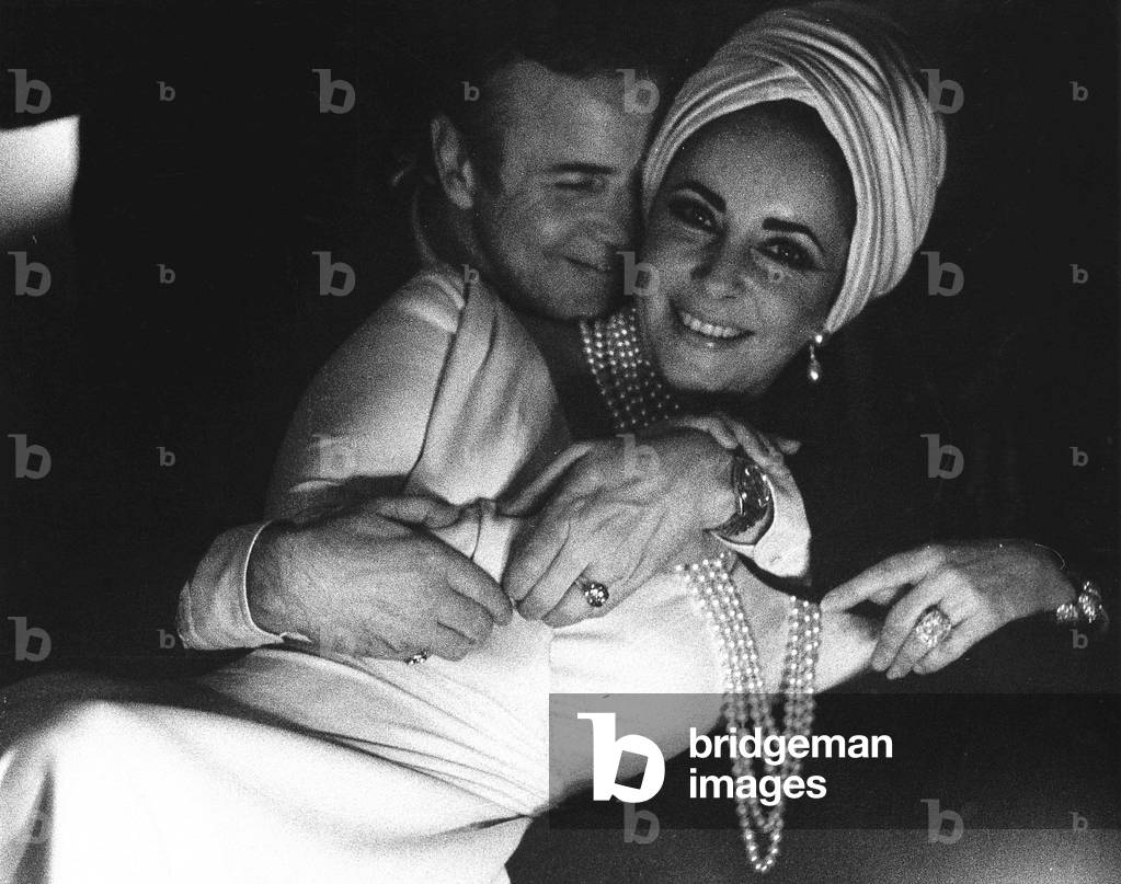 Liz Taylor and Franco Zeffirelli during a party at the Falk house following a show at the Teatro alla Scala, Milan, Italy, 1971 (b/w photo)