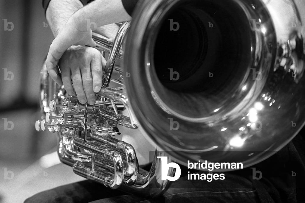 tuba lied on the leg of the musician.