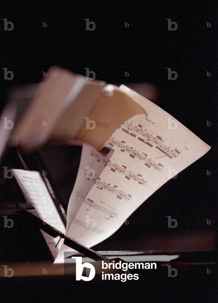 Sheet music on the stand of a piano. Reflection
