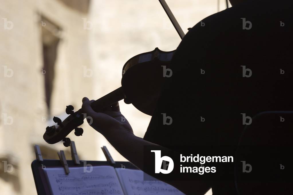 Violin being played - silhouette. Outdoors at Summer Festival.