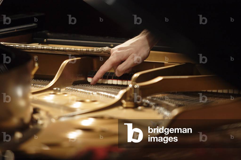 Piano tuner tuning a piano.