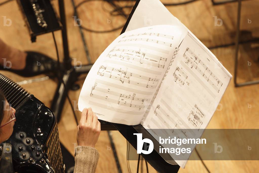 Fisarmonicista che sfoglia una partitura su un leggio, ottobre 2006.