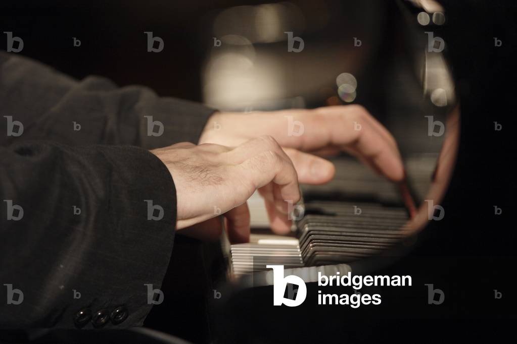 Pianist's hands on a piano.