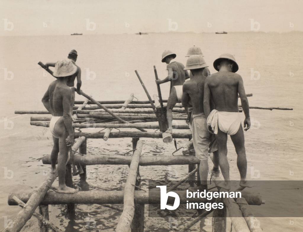 Japanese prisoners building the jetty on Rempang Island, 1945 (b/w photo)