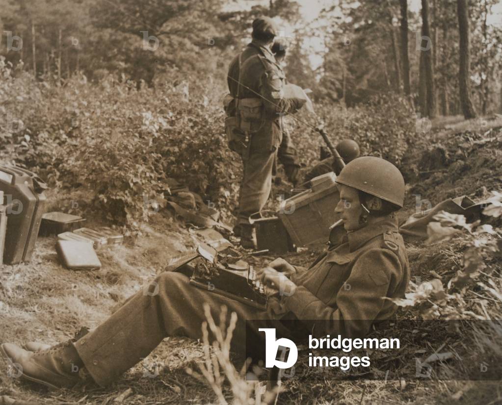 War correspondent Alan Wood typing out a despatch, 1944 (b/w photo)