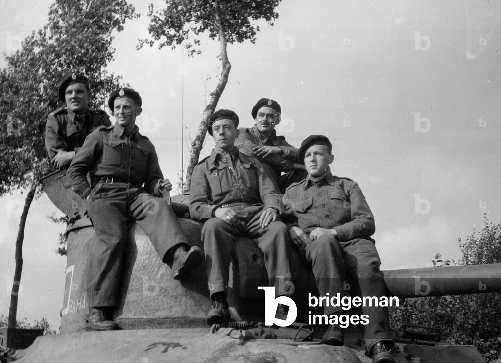 Personnel of B Squadron, 3rd/4th County of London Yeomanry (Sharpshooters) pose on the turret of a Sherman tank, 1944 circa (b/w photo)