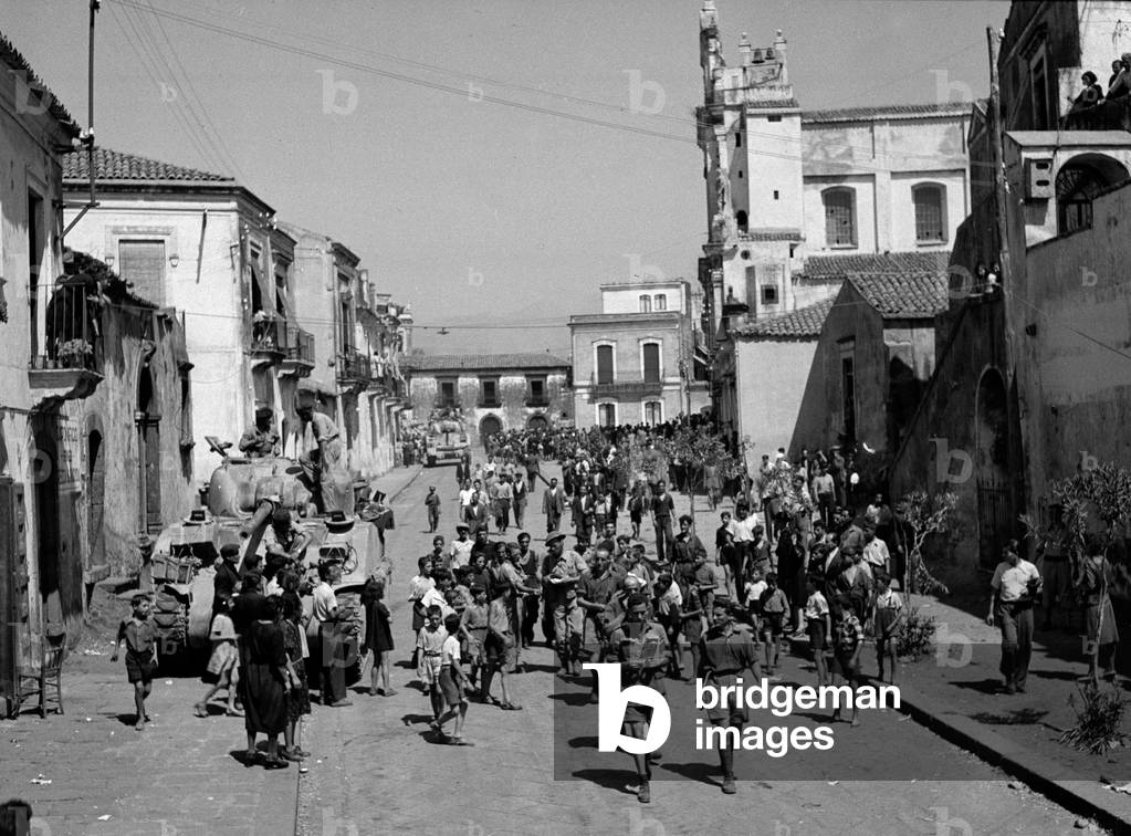 Civilians and British soldiers escort prisoners at Mascalucia, 1943 (b/w photo)