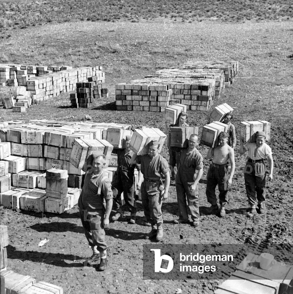 A compo ration dump and men carrying more supplies to it, March 1943 (lantern slide)