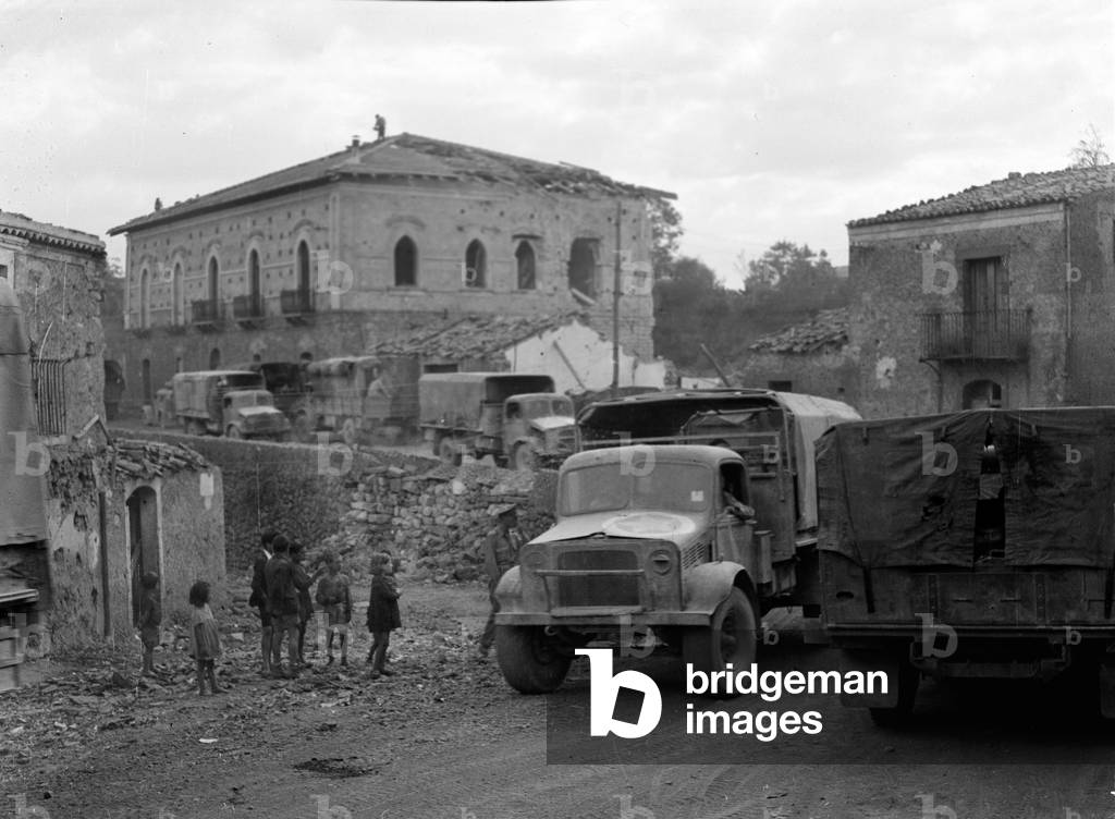British trucks in the battle-damaged town of Bronte, Sicily, 1943 (b/w photo)