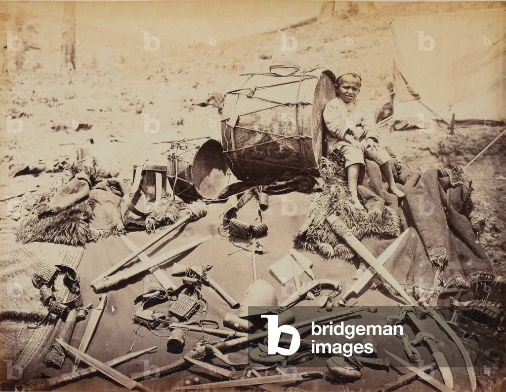Child seated amongst Afghan weapons, 1880 (b/w photo)
