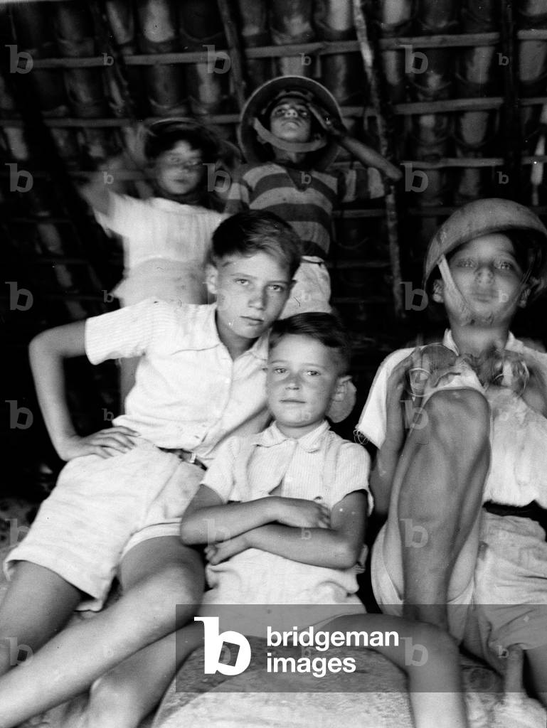 Refugee children wearing British steel helmets, Nicolosi, Sicily, 1943 (b/w photo)