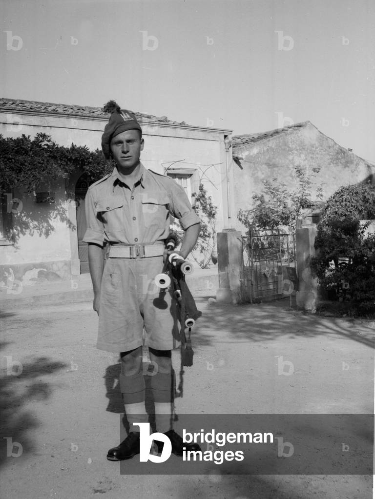 Regimental piper, 6th Battalion, The Royal Inniskilling Fusiliers, Sicily, 1943 (b/w photo)