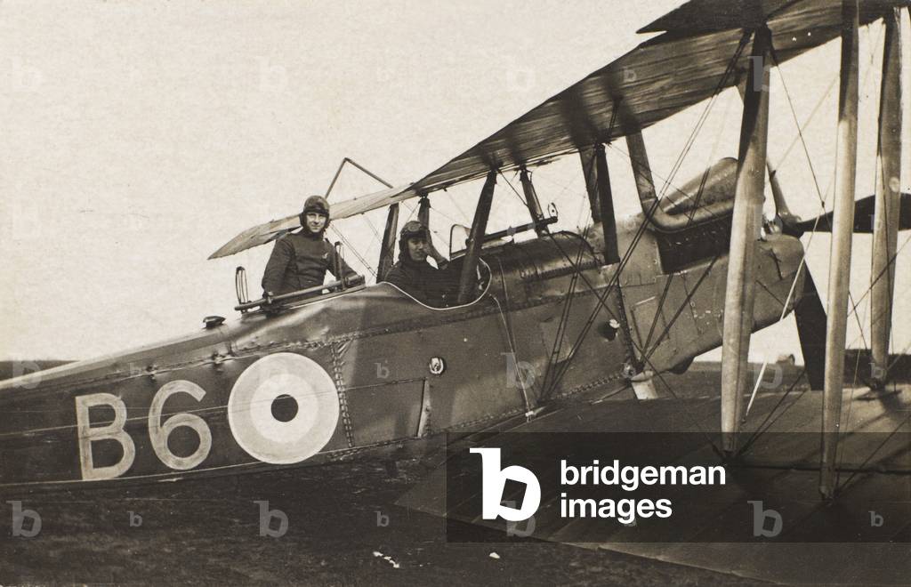 A Royal Aircraft Factory RE8 reconnaisance aircraft, right view, standing on a grass airfield with it’s crew in the cockpits, c.1917-18 (b/w photo)