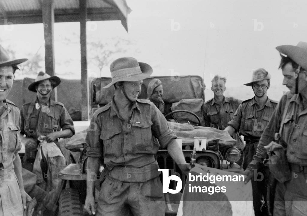 Seven soldiers gathered around a jeep, from an official collection of photos from the Middle and Far East during World War Two compiled by Major General Messervy (b/w photo)