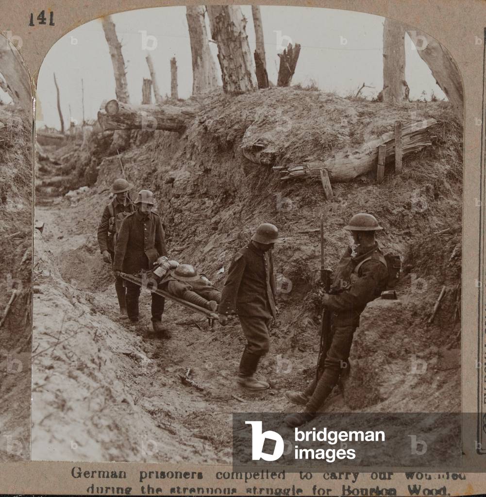German prisoners compelled to carry our wounded during the strenuous struggle for Bourlon Wood, 1917 (b/w photo)