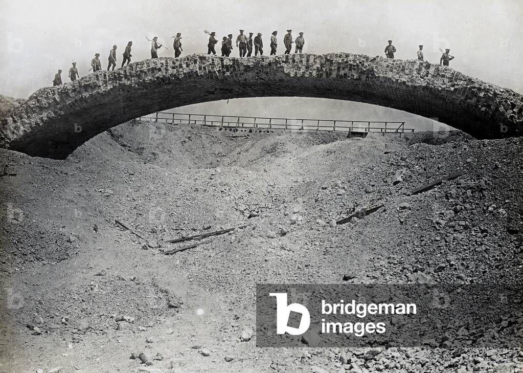 Photograph of working party crossing ruined bridge (b/w photo)