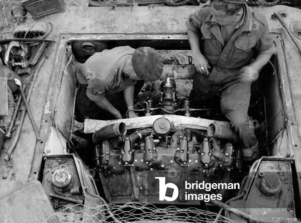 Ronnie Grant and Sid Hicks working on a tank engine, 1944 (b/w photo)