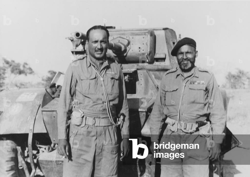 Two Indian officers standing in front of a Daimler Armoured Car, 1943 circa (b/w photo)