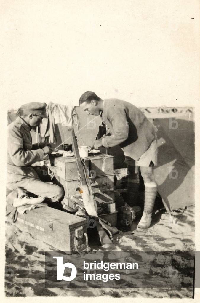 British soldiers eating breakfast on a table made from ammunition boxes at their desert camp in Palestine, October 1917 (b/w photo)