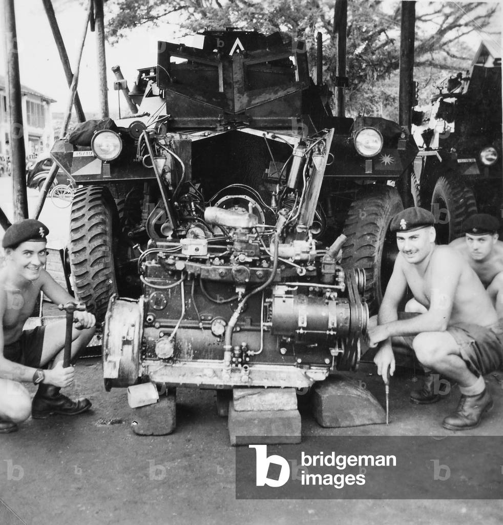 Three Royal Electrical and Mechanical Engineer craftsmen repairing the engine of an 'A' Squadron, 15/19th King's Royal Hussars Saracen Armoured Personnel Carrier, Malaya, c.1957 (photo)