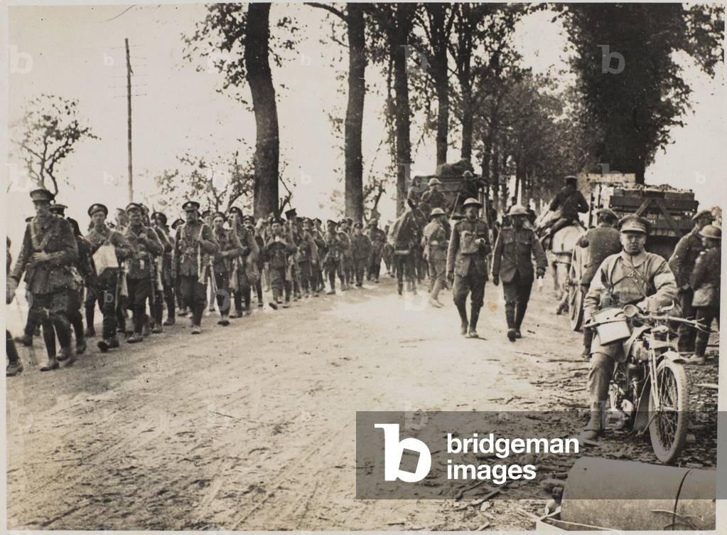 The Manchesters and details marching forward to the lines in July, 1918, to assist in smashing the German Hordes (b/w photo)