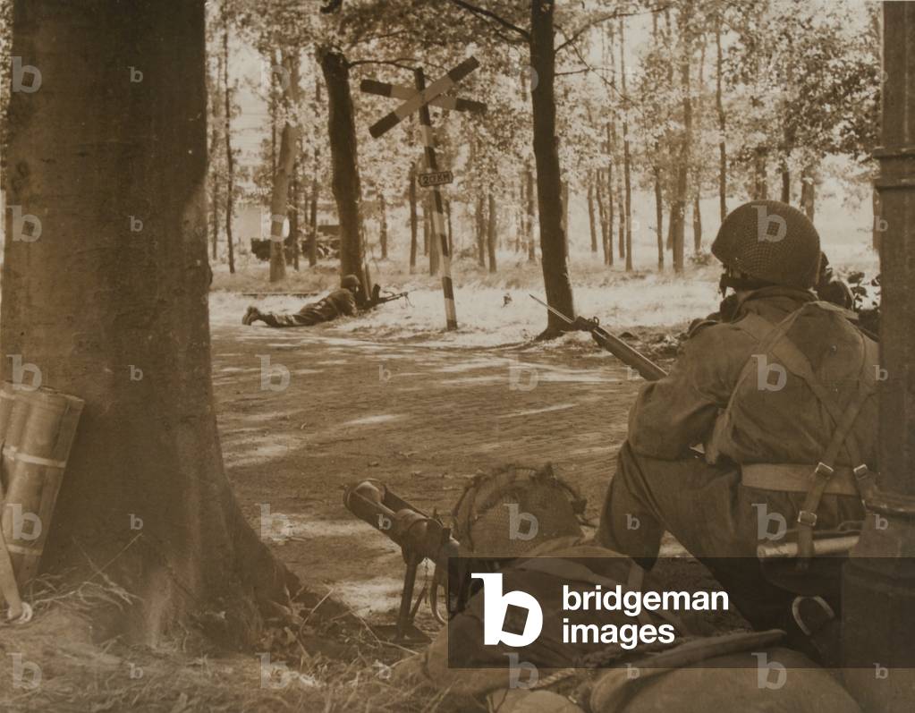 A paratrooper armed with a PIAT covers a road at Arnhem, 1944 (b/w photo)