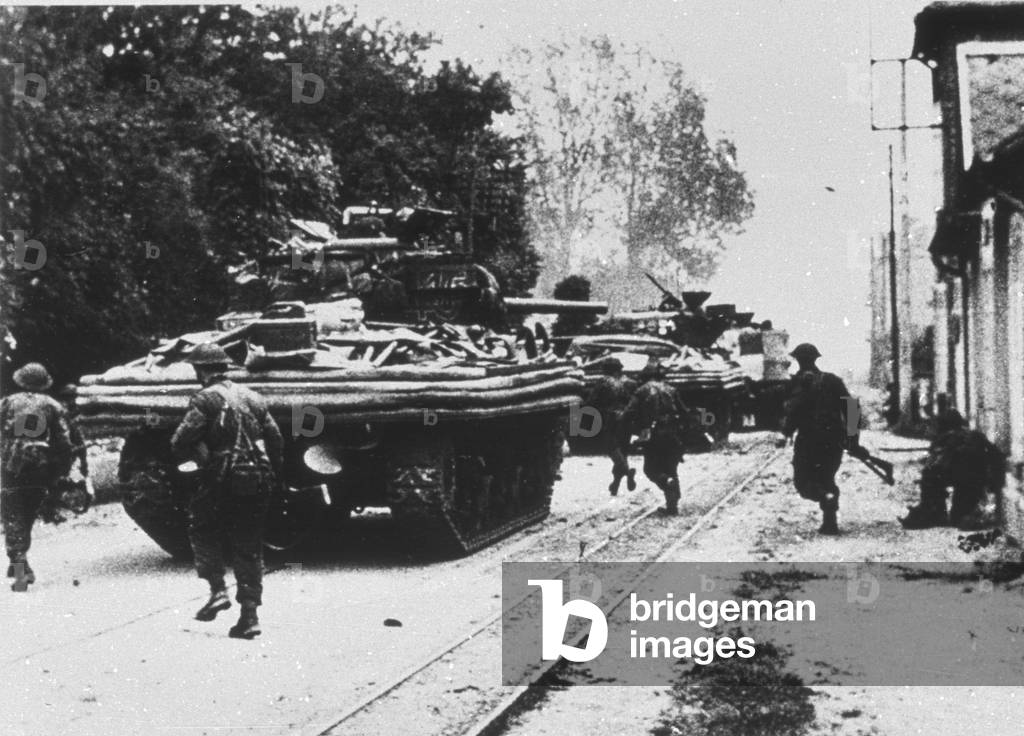 Amphibious tanks moving through a town, June 1944 (b/w photo)