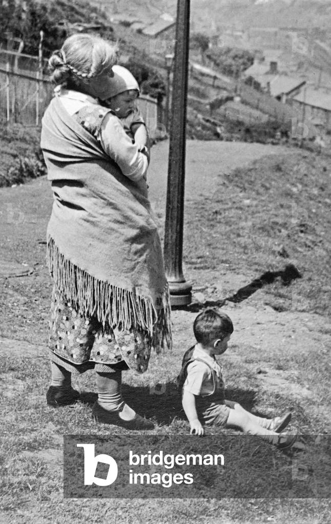 Mother holding baby in a shawl, 1930 (b/w photo)