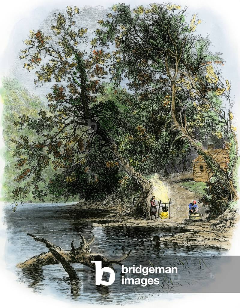 History of the West Conquete settlers: American pioneers. A woman cooks near her wooden house on the banks of the Susquehanna River, Pennsylvania. Coloured engraving of the 19th century.