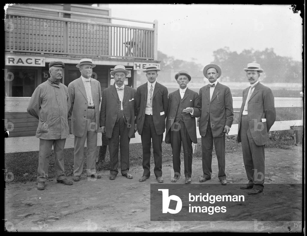 Seven unidentified men pose near a river or lake, c.1910 (b/w photo)