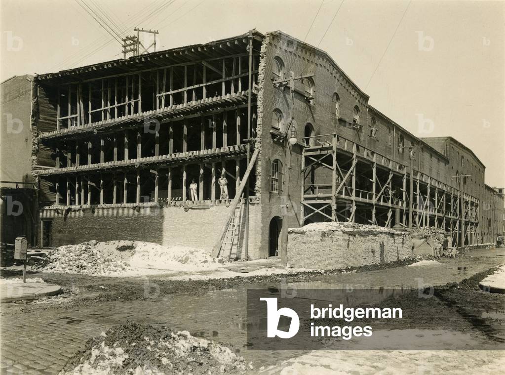 Construction site, two men standing in open side of warehouse building; Robbins & Ripley Engineers and Contractors, March 23, 1916 (b/w photo)