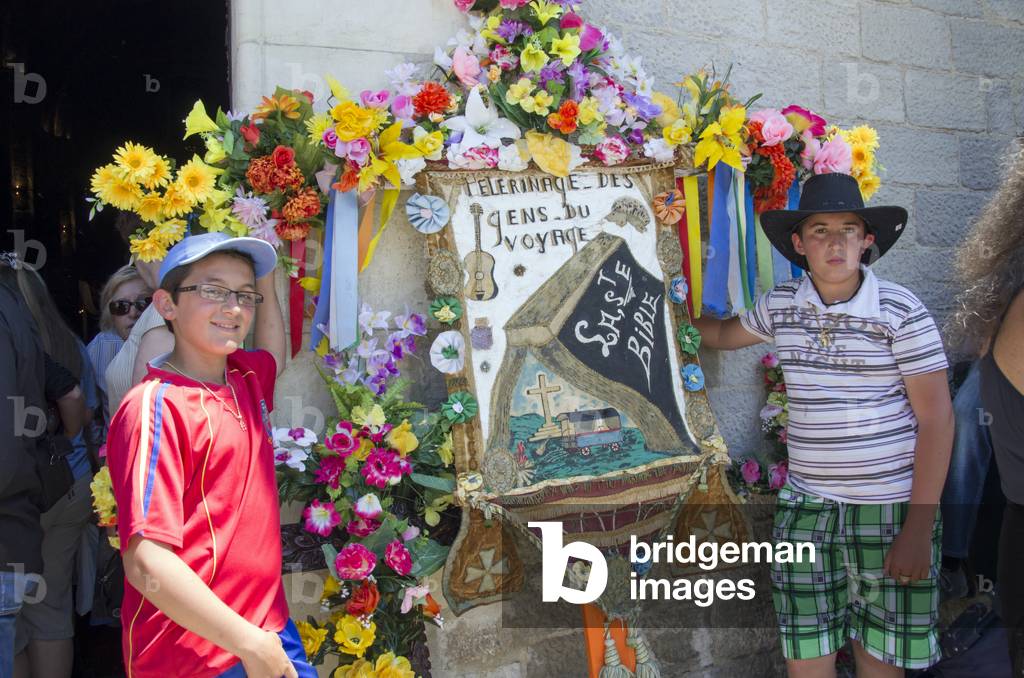 Boys with religious display panel, Saintes-Maries-de-la-Mer pilgrimage, May 2012 (photo)