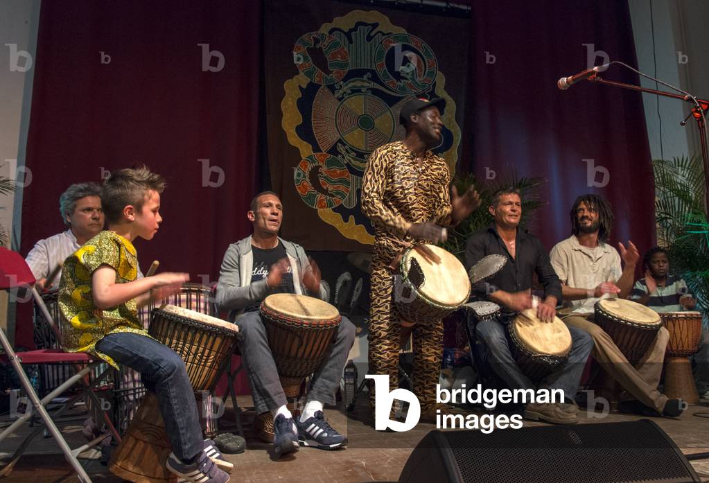 Multiracial percussionists playing African drums