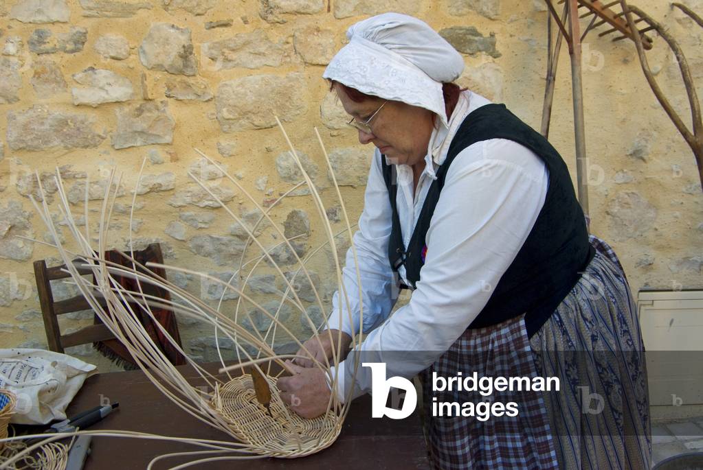 Female basket weaver in old-fashioned dress