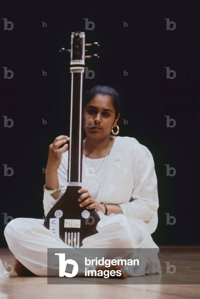 Female Indian musician playing a tambura