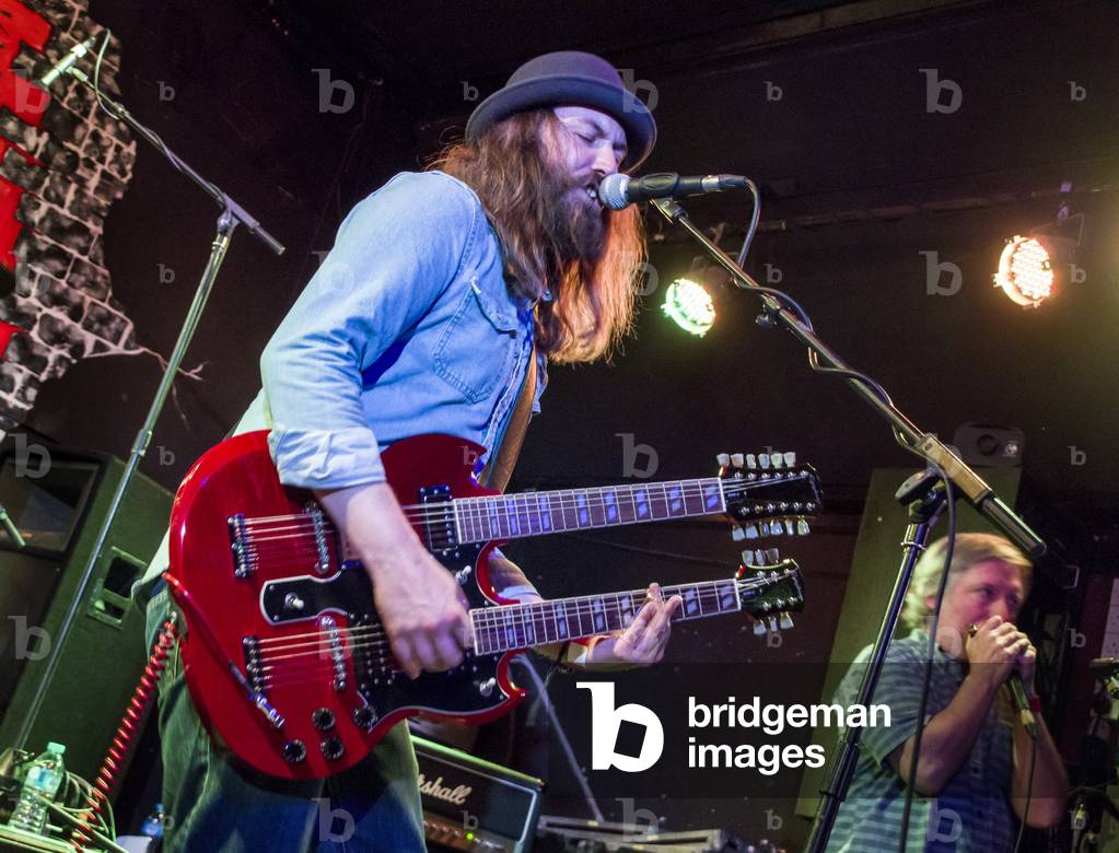 Guitarist playing a twin-neck electric guitar (photo)
