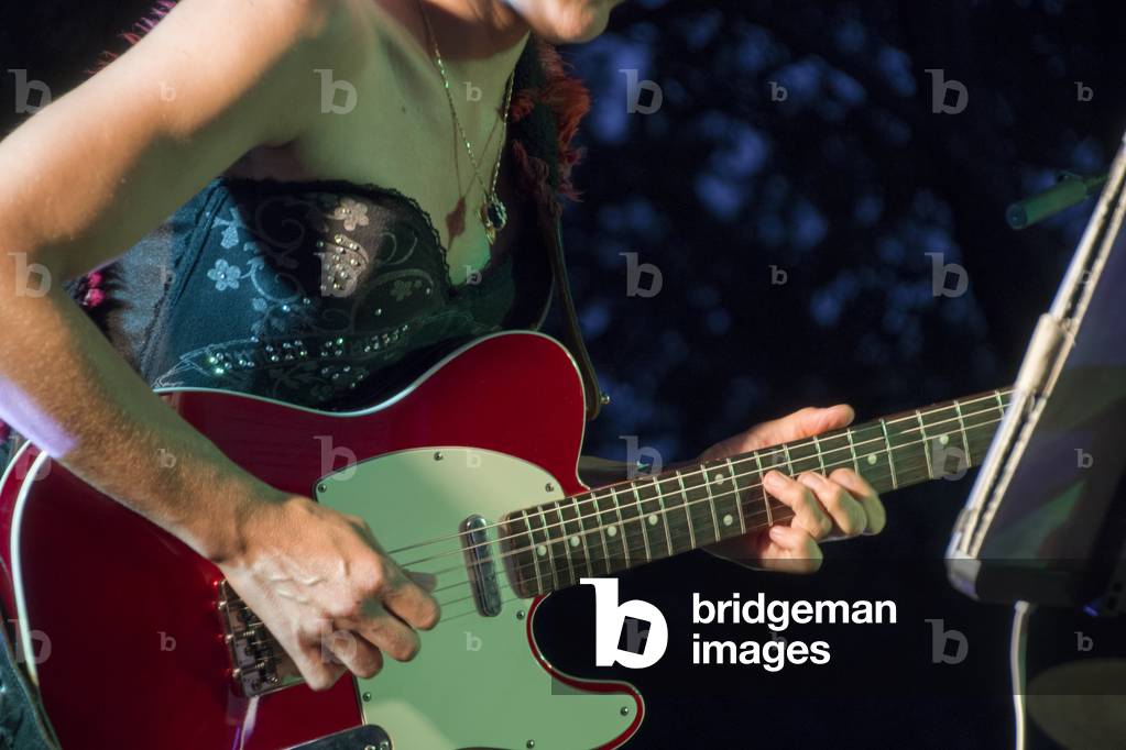 Close-up of female electric guitarist in action (photo)