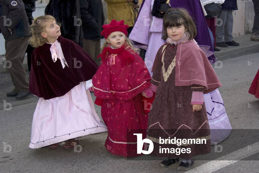 Three small girls in Victorian costumes