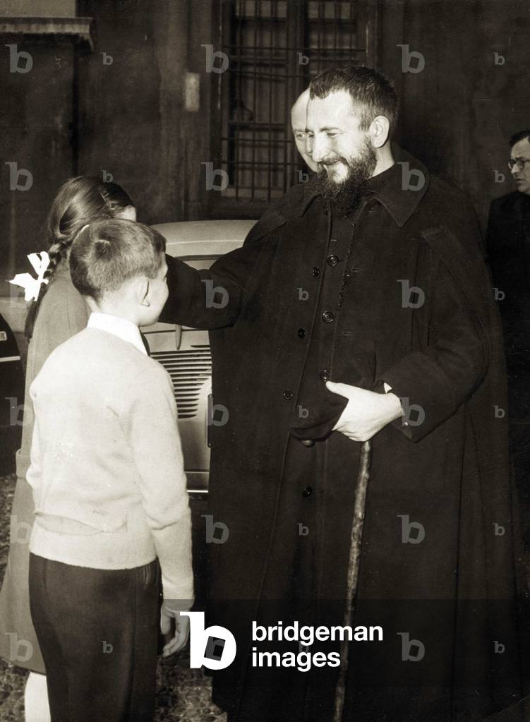 Milan 23/04/1956 Portrait de l'Abbe Pierre (ne en 1912), fondateur d'Emmaus et protecteur des sans abris, lors d'un entretien avec des enfants. 